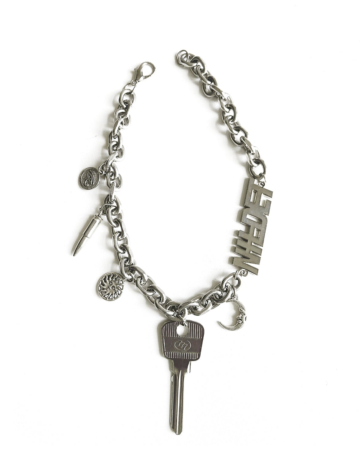 Silver necklace with a key and various charms on a white background