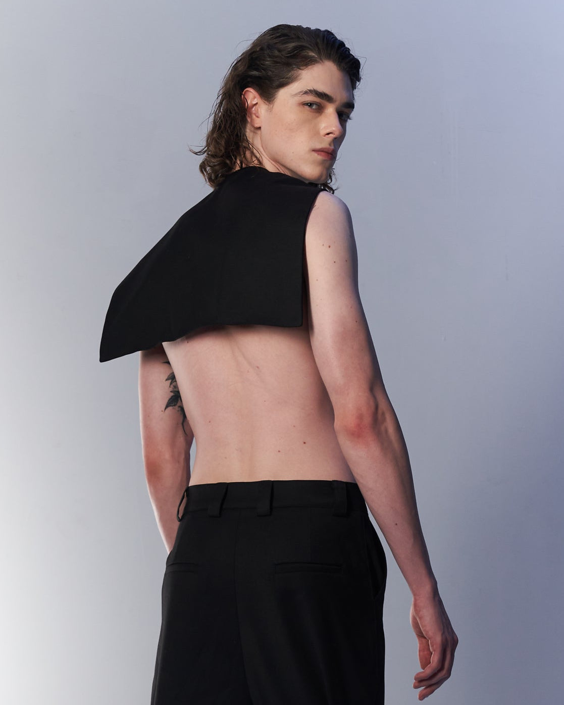 Person wearing a black outfit with a unique design on a white background