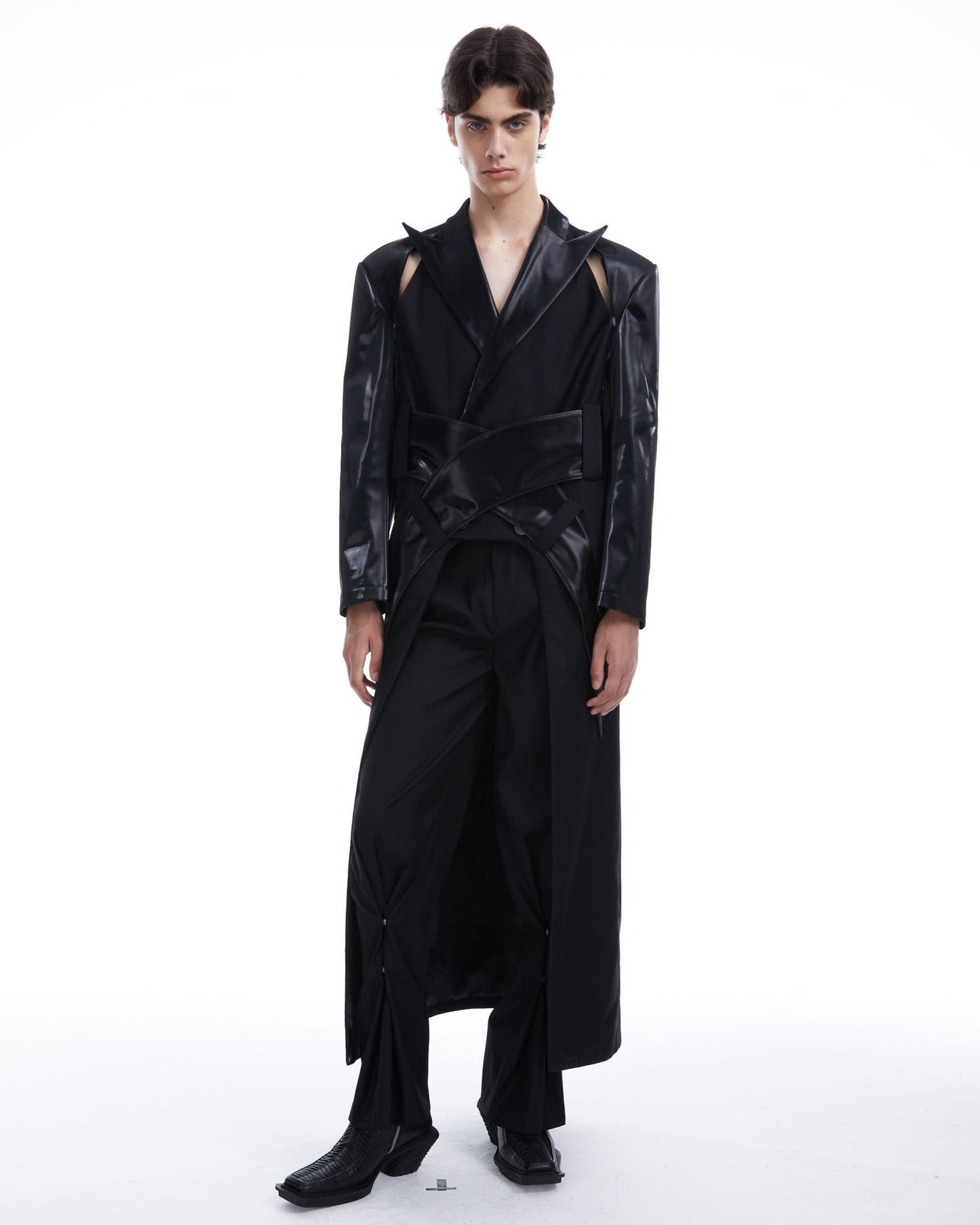 Person wearing a black outfit with a textured design on a white background