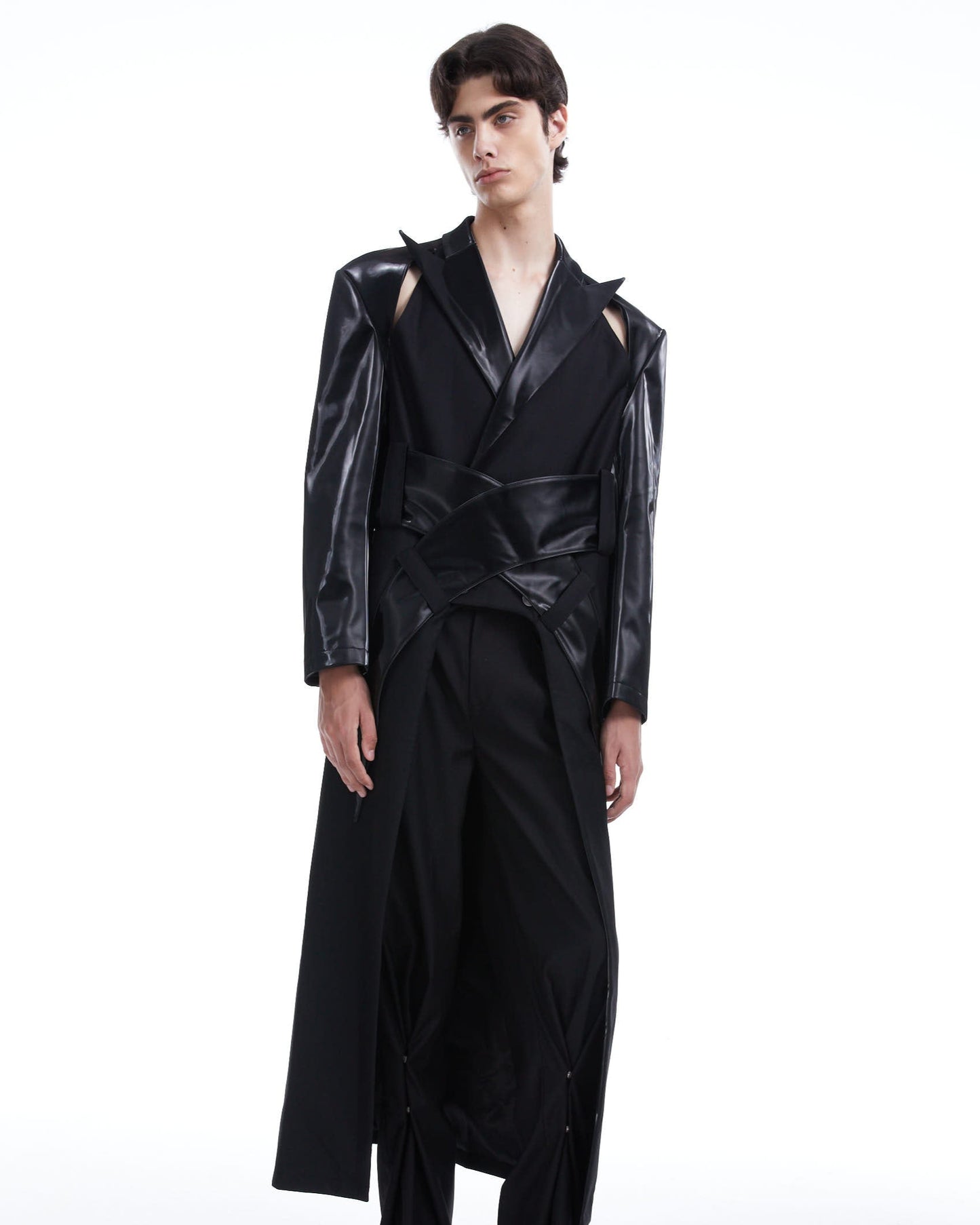 Person wearing a black outfit with glossy texture on a white background