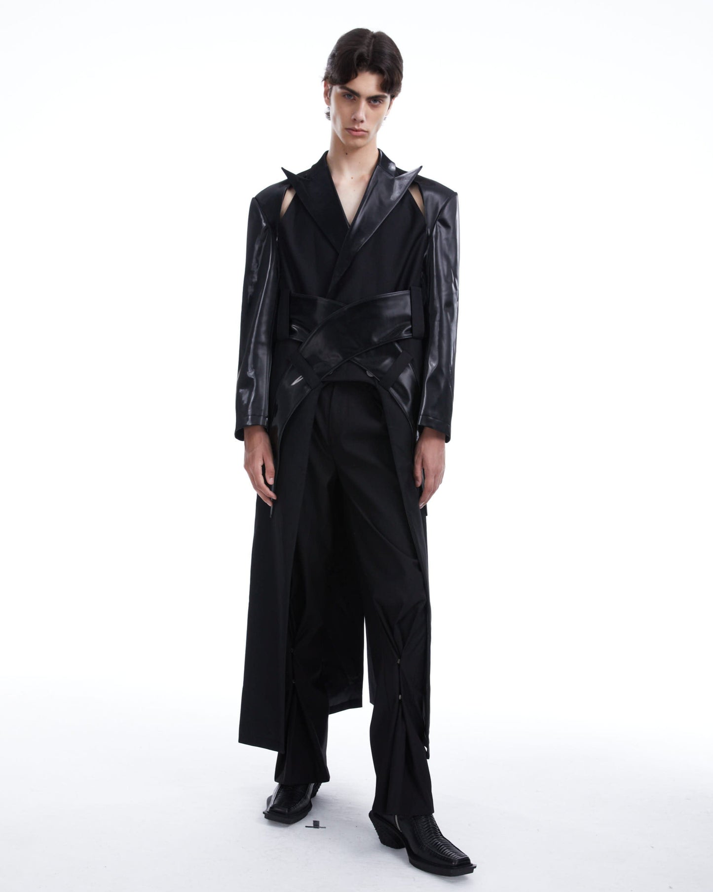 Model wearing a black leather jacket and pants on a white background