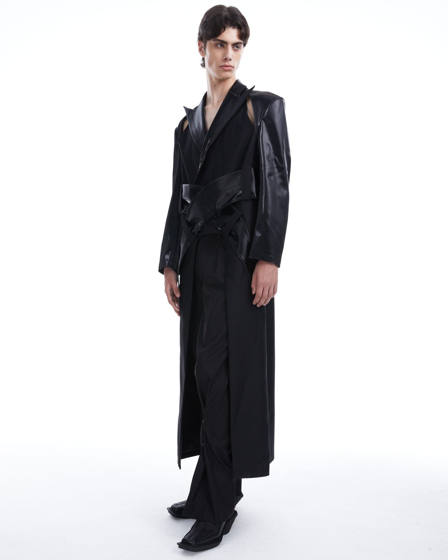 Person wearing a long black coat on a white background