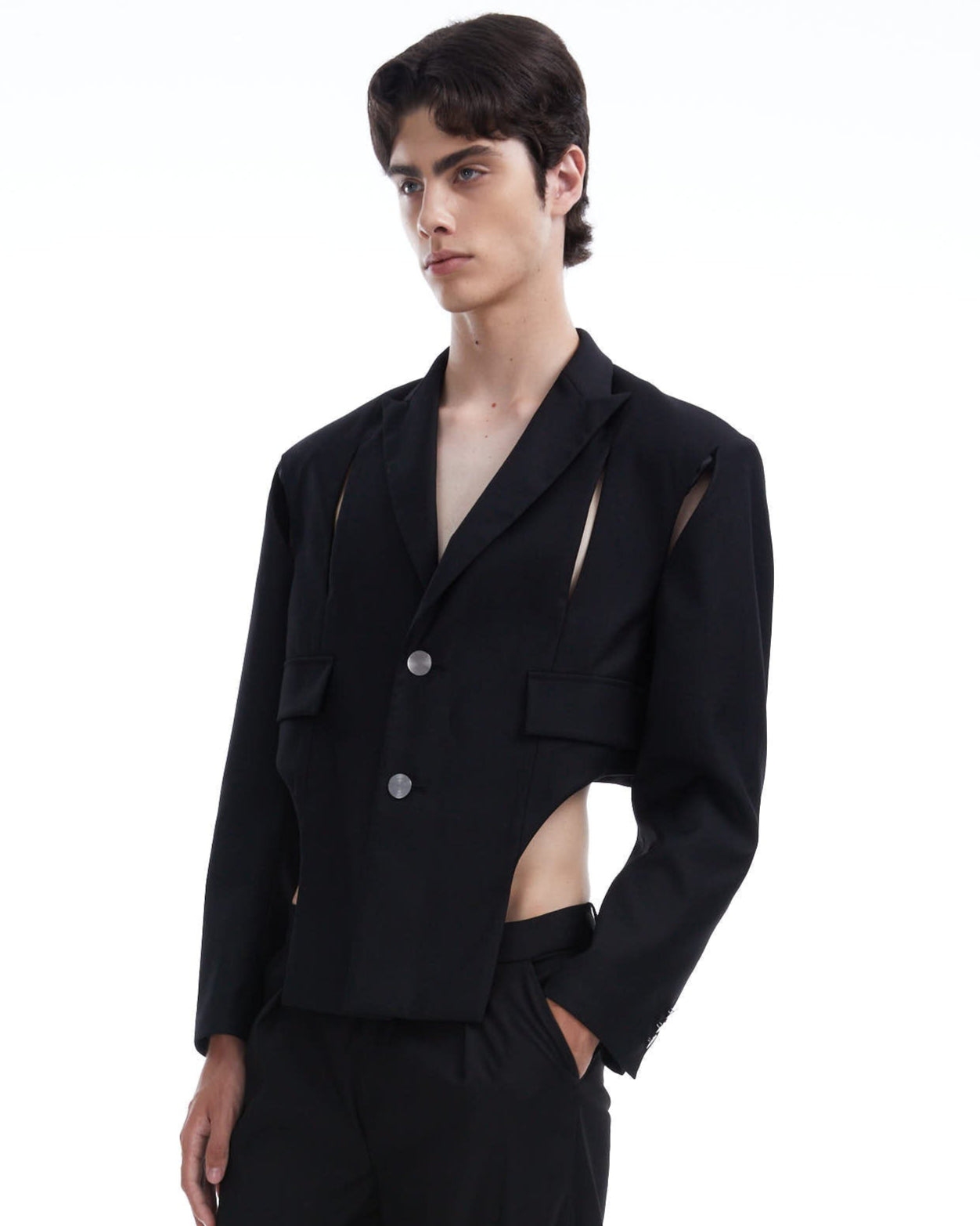 Person wearing a black blazer with cut-out details on a white background