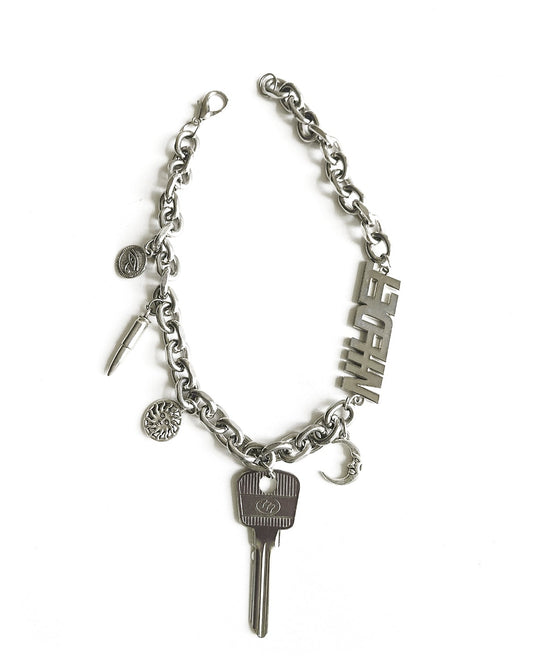 Silver necklace with a key and various charms on a white background