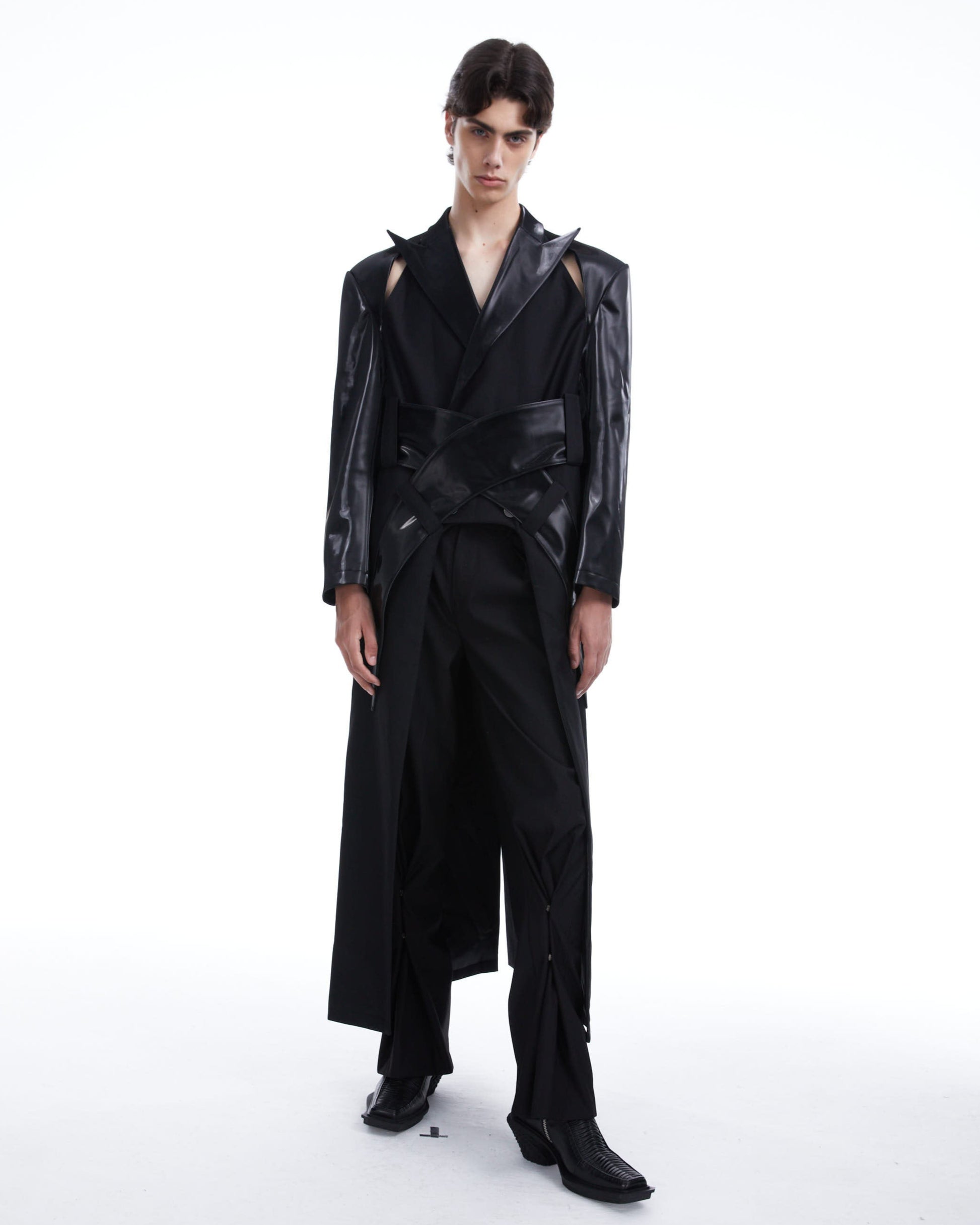 Model wearing a black leather jacket and pants on a white background