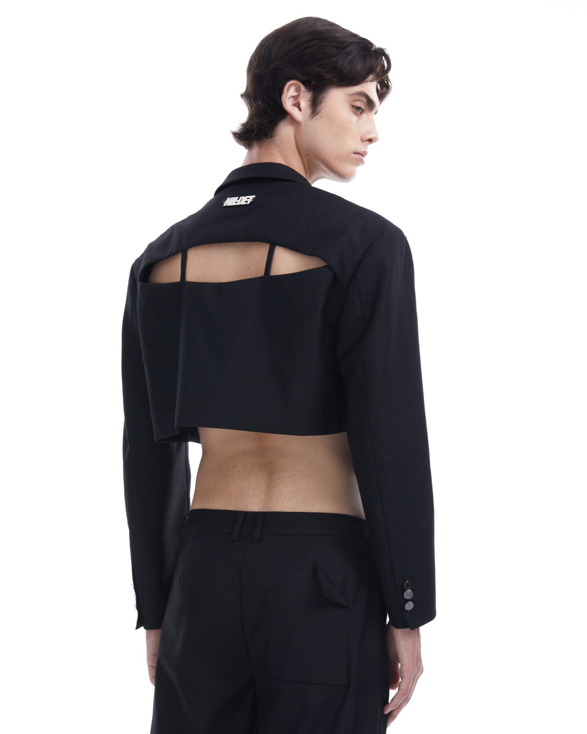 Person wearing a black jacket with cut-out design on a white background