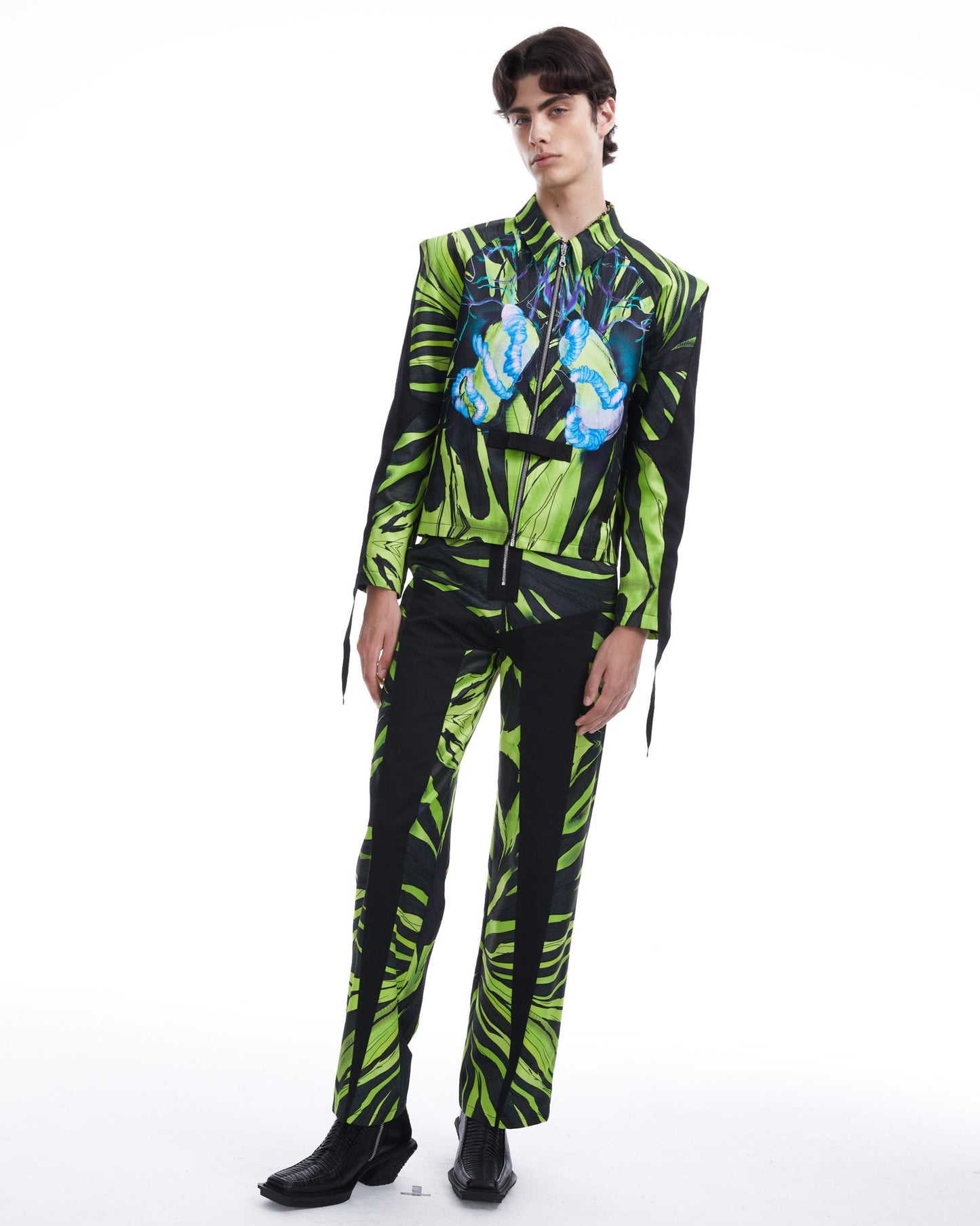 Person wearing a green and black patterned outfit on a white background